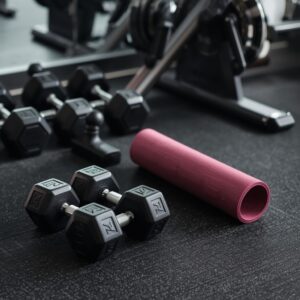 Home gym equipment with dumbbells and a yoga mat arranged neatly in a bright, modern space